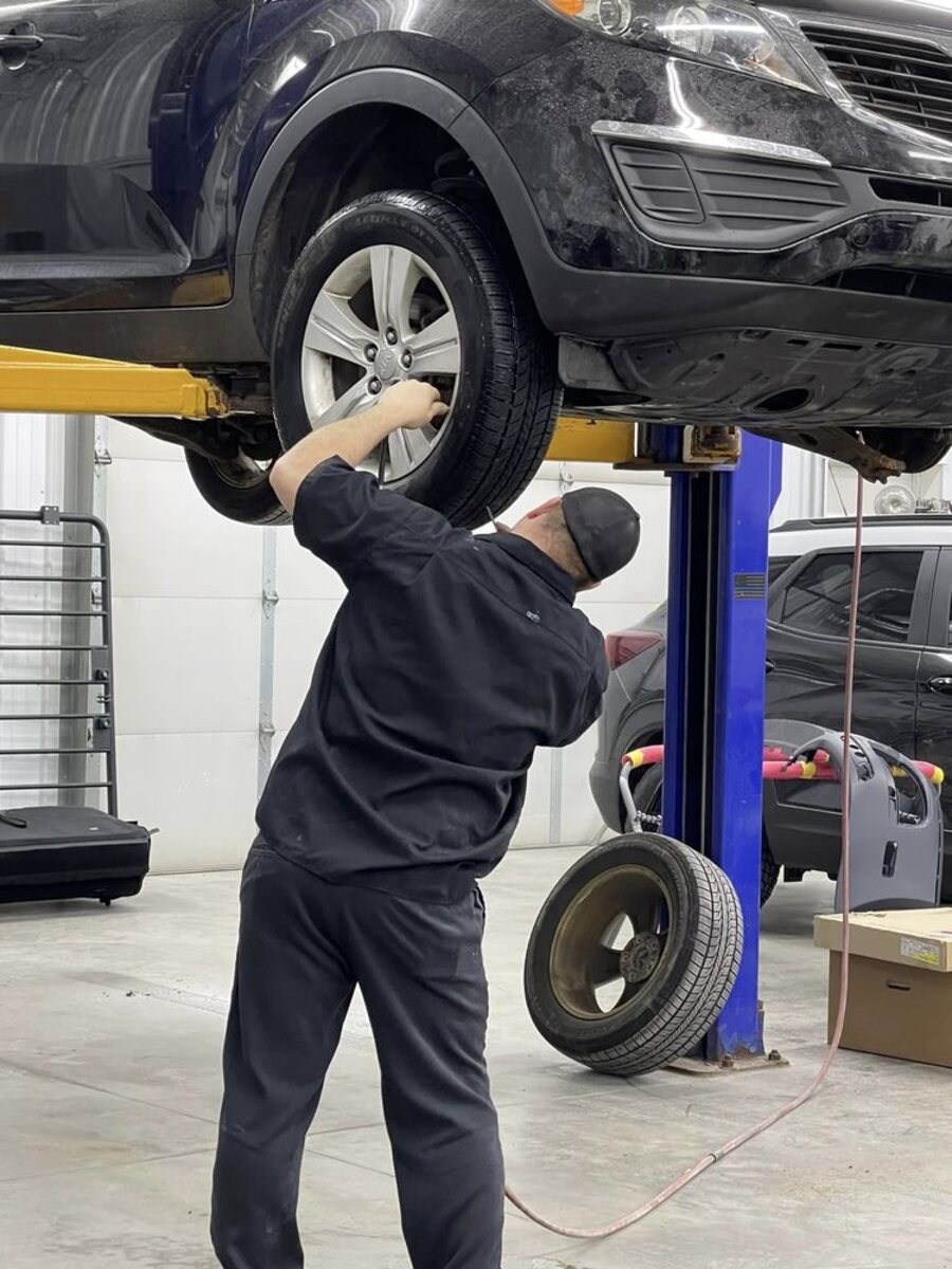 A technician removing a wheel on the lift at SouthSide Body & Bike