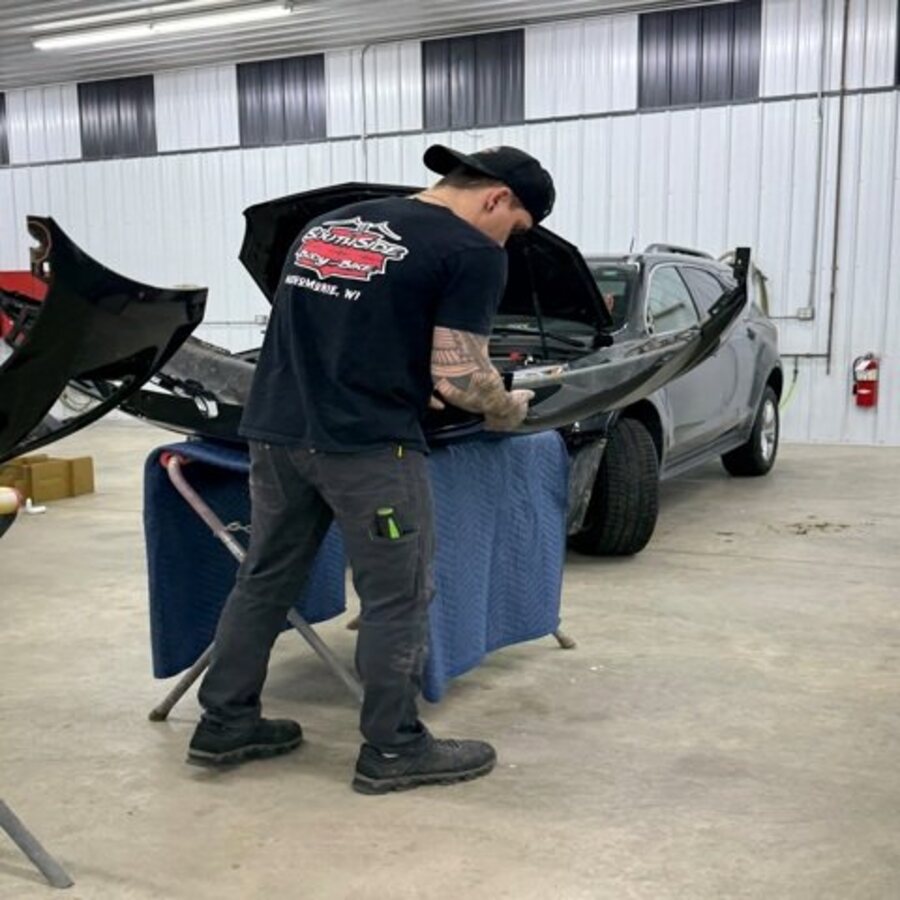A technician working on a vehicle in the SouthSide Body & Bike shop